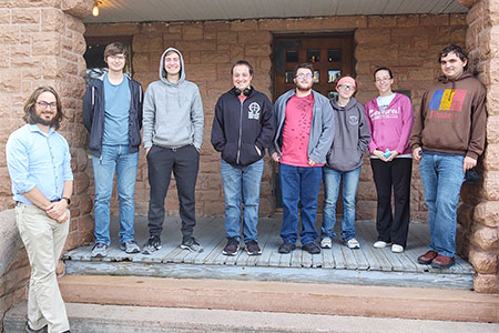 a group poses for a photo in front of the Frank House Museum