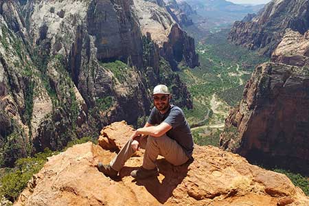 Will Stoutamire posing for a picture sitting in front of mountains