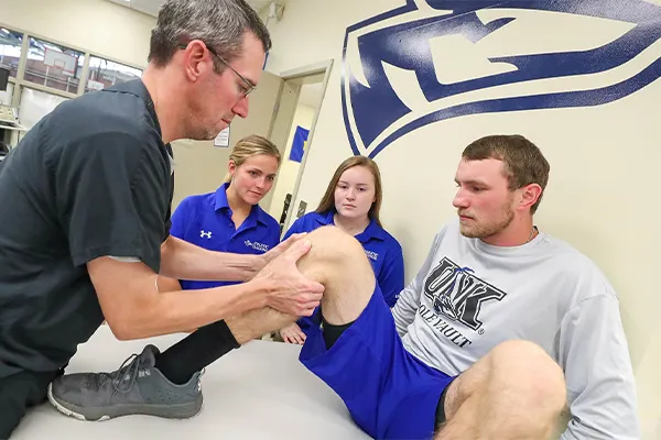 an athletic training instructor works with a patient