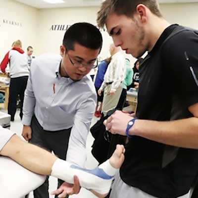 Athletic training student wrapping an injured ankle