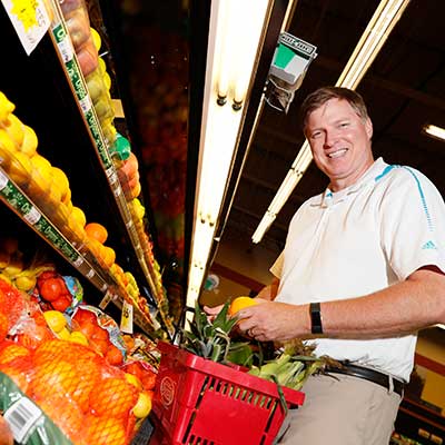 Todd Bartee picking fruit from a shelf
