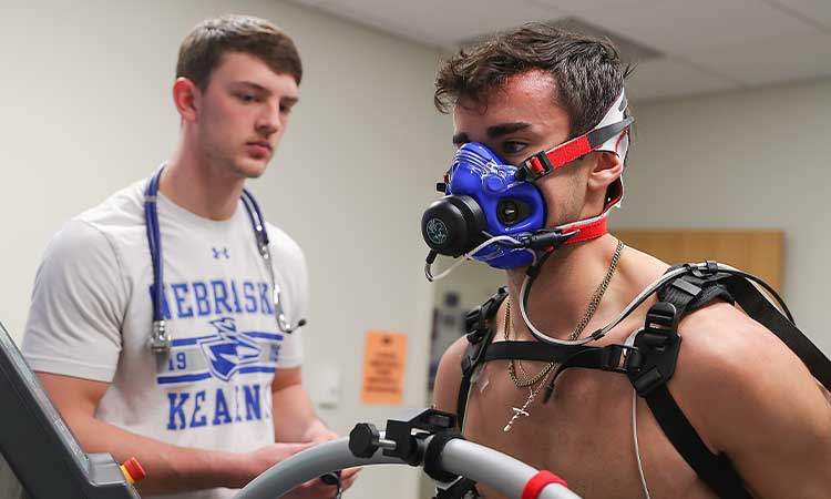 teacher and students affixing a breathing apparatus to an athlete