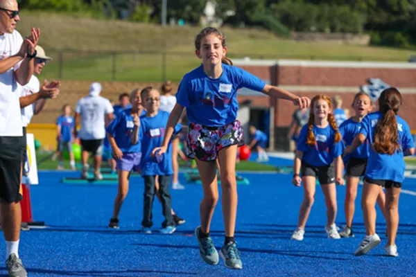 a teacher works with a student during a fitness day activity