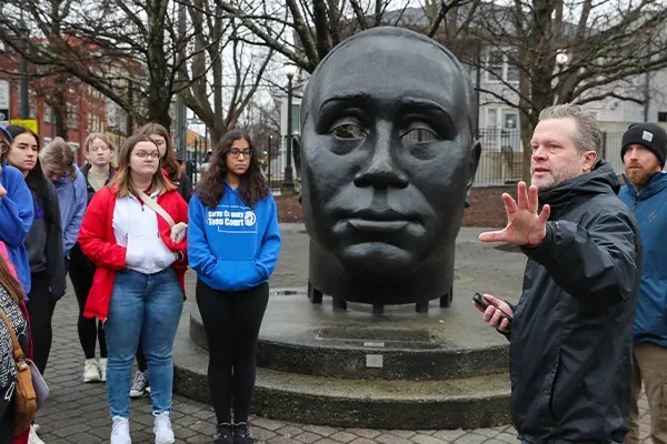 an instructor gestures to a landmark on a class trip