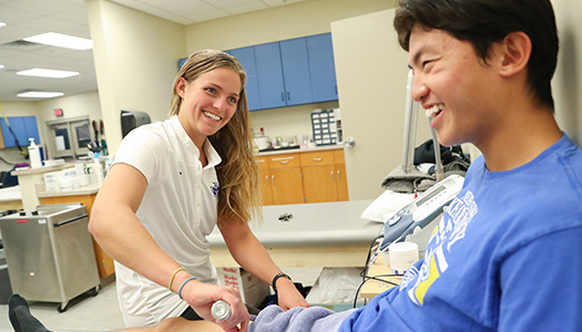 an athletic training student helps a patient recover in a clinic