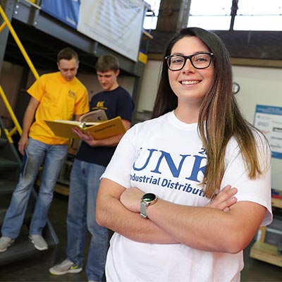 a students poses in an Industrial Distribution lab