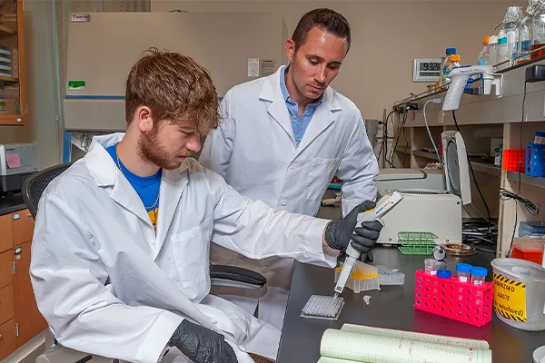 a student and professor work in a lab
