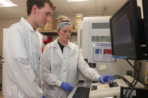 A technician shows a UNK student a microbiology lab