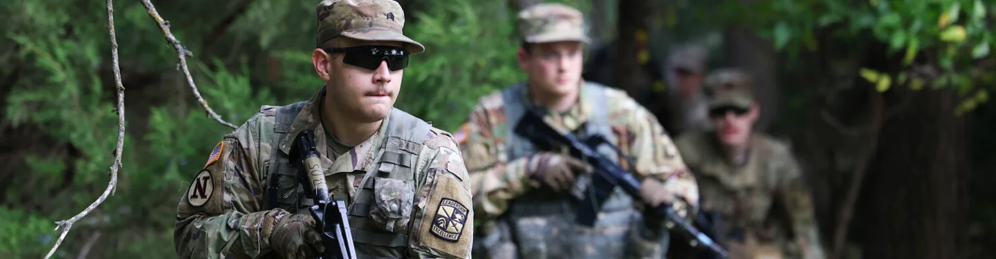ROTC students walk through a forest during training
