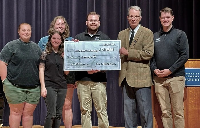 On May 9, 2024, Dr. David Nabb receives a check from the UNK NAfME (National Association for music Education) Chapter.
