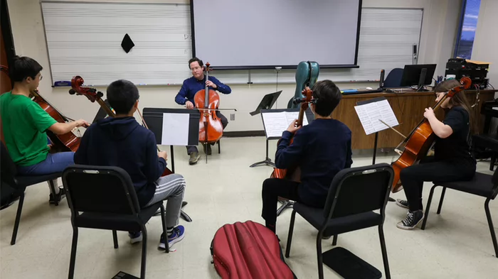 UNK music professor Noah Rogoff teaches students in the UNK String Projec