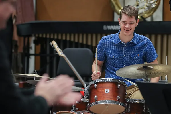 a music education student plays drums