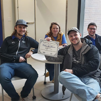 a competition team holds up their registration certificate