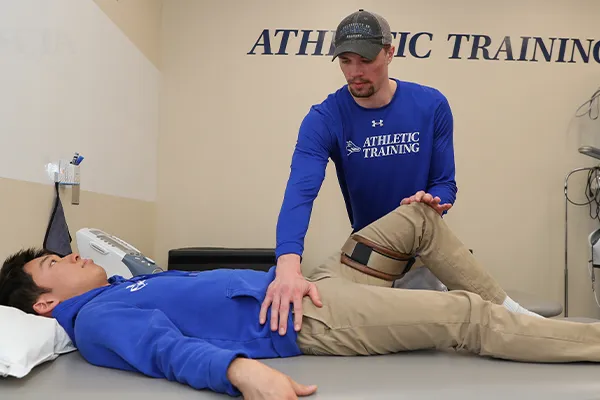 an athletic trainer works with a patient 