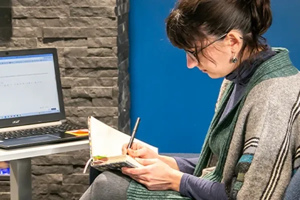 a woman writes in a notebook