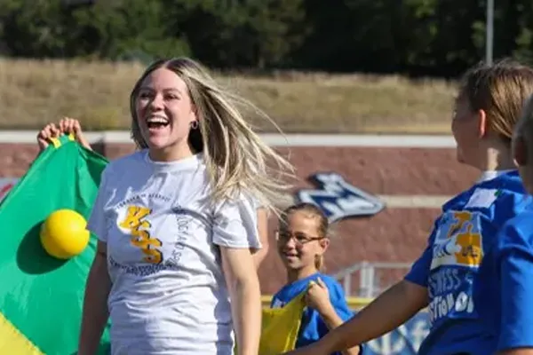 a physical education student works with kids during a fitness day