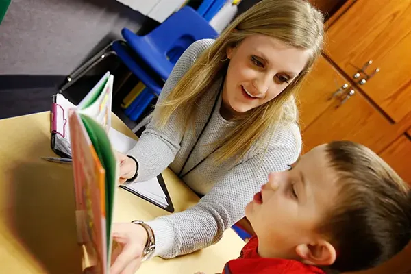 a teacher reads with a young child