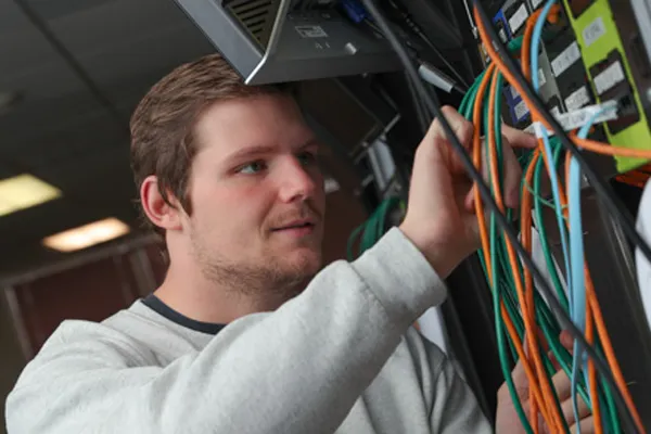 a student works with networking equipment