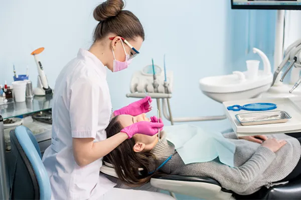 a Dental hygienist works with a patient