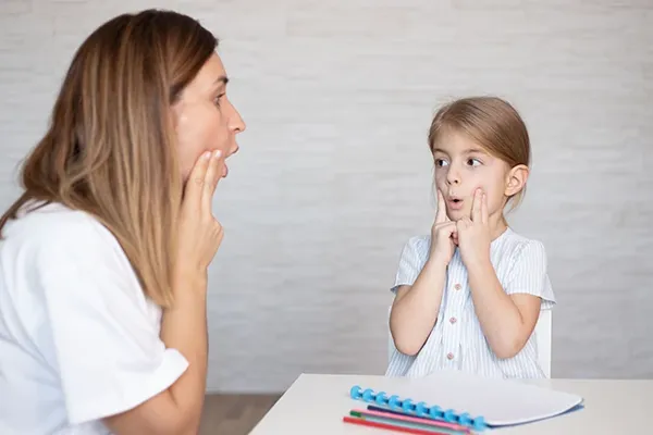 a Speech-language pathologists works with a child