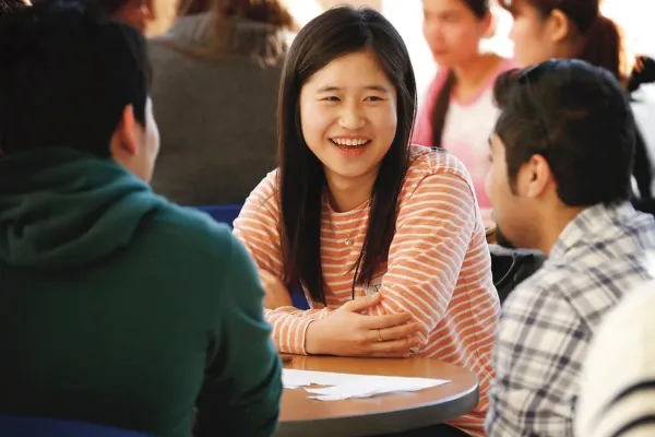 stock photo of students talking at tables