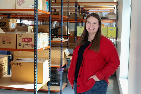 a student poses for a photo in a warehouse