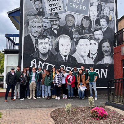 students in front of political art