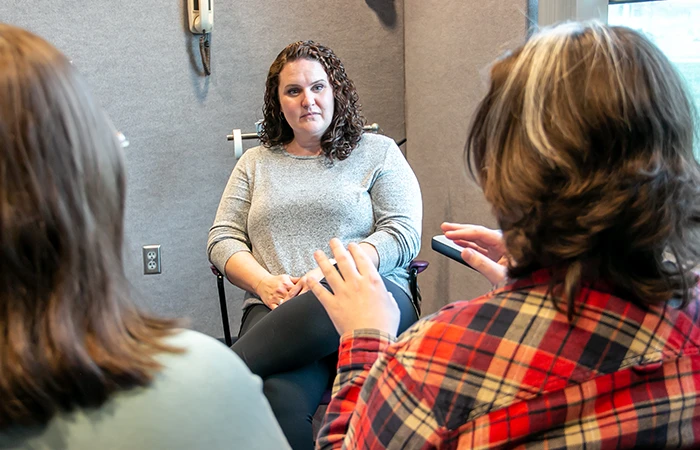 a woman works with patients in a counseling setting