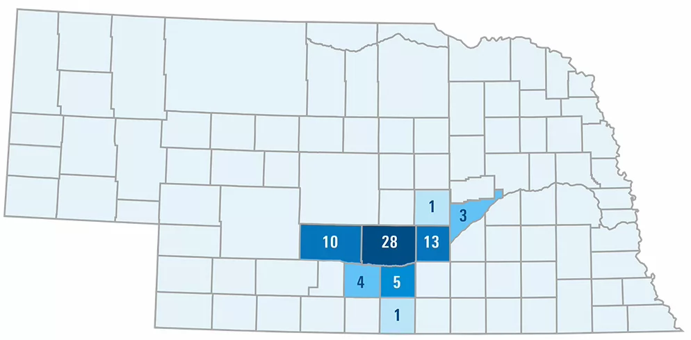 a map of nebraska showing counties with the number of member schools. Dawson 10, Buffalo 28, Hall 13, Merrick 3, Howard 1, Kearney 5, Phelps 4, Franklin 1