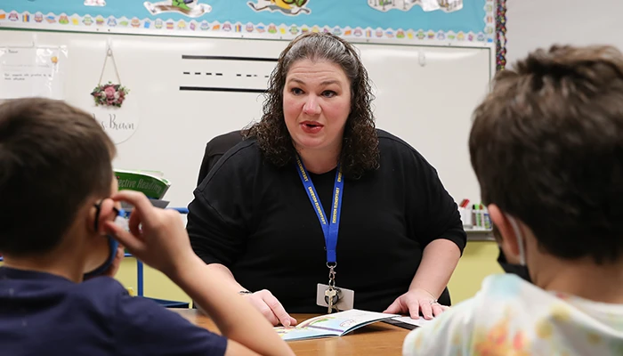 a teacher talks with two students