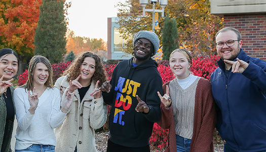 a group of students smiling for a posed photo outdoors