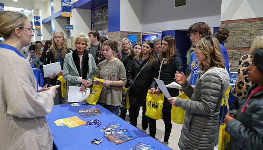 students and parents visit a table during admitted student day