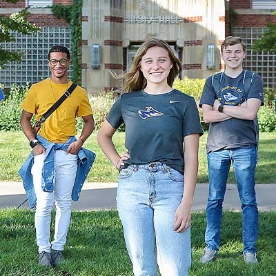 students stand in front of a residence hall