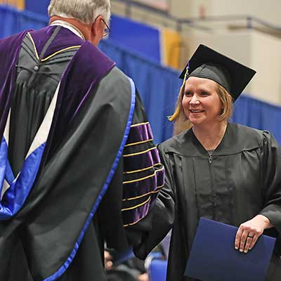 a student shakes the chancellors hand during graduation