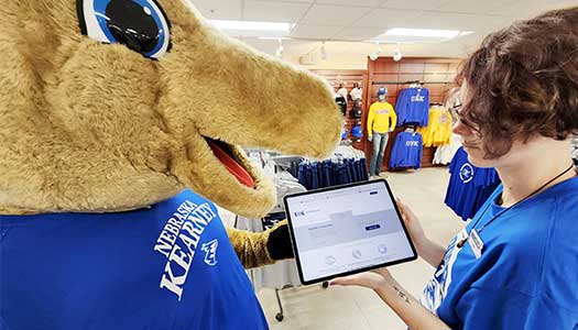 a worker browses the UNK Online bookstore with louie the loper