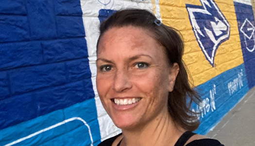 Dr. Shannon Mulhearn completing her Daily Mile in front of a UNK themed mural in downtown Kearney, Nebraska.