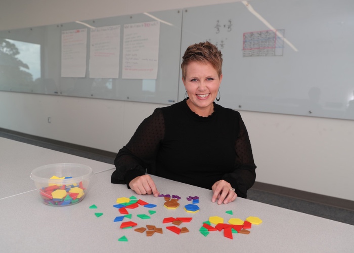 Teacher at desk with tile shapes