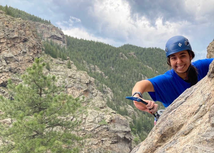 Woman rock climbing mountain.