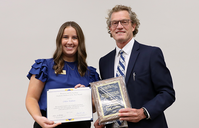 Chloe Dakan receiving the College of Business and Technology Graduate Student of the Year Award from Graduate Dean Ellis.