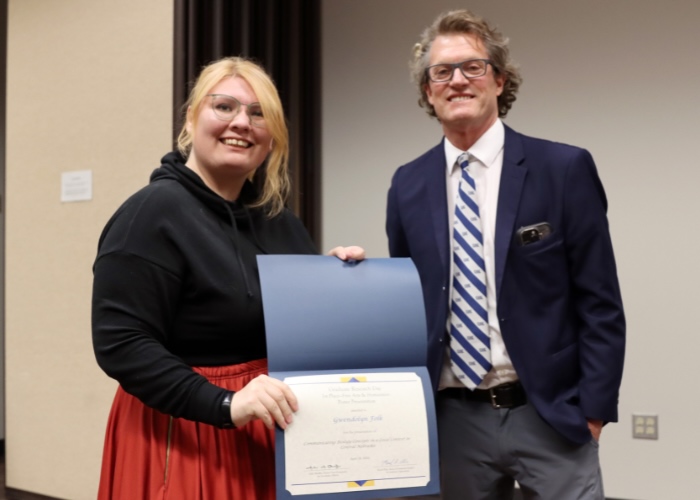 Man presenting a woman an award.