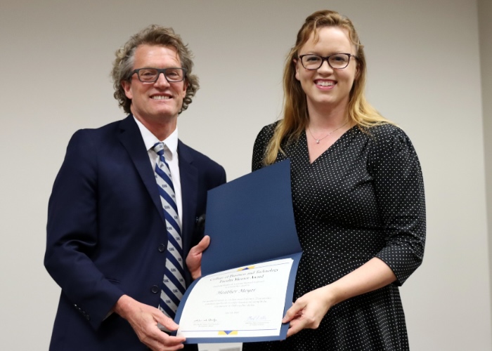 Man presenting an award to a woman.