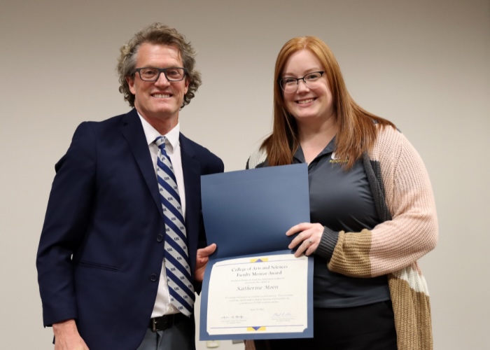 A man presenting an award to a woman.