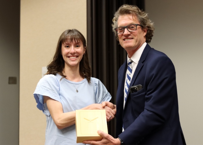 A man presenting an award to a woman.