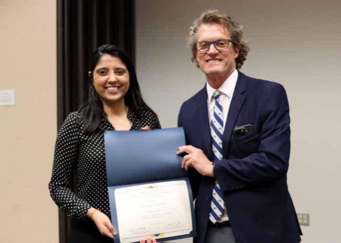 Man presenting woman with award.