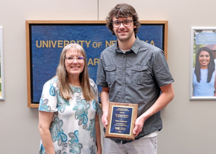 Student and professor pose with award.