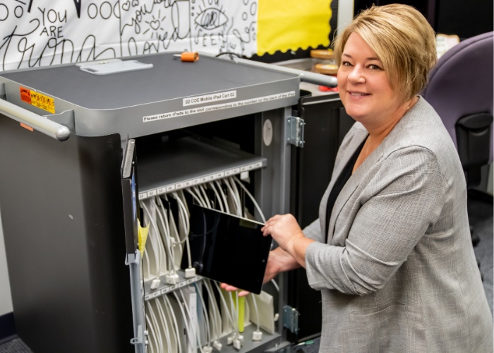 Woman returning Ipads to cart.