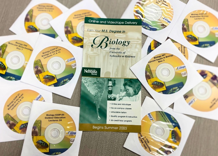 Former DVD Biology lectures with 2023 pamphlet showcasing the new online master's program.