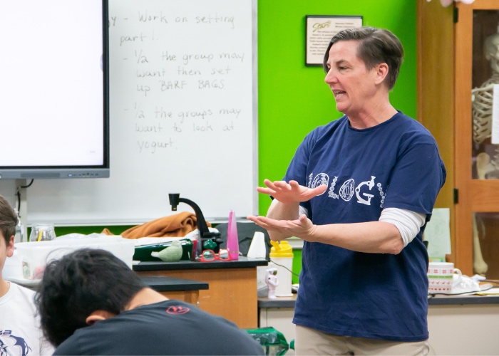 High school biology teacher in class with students.