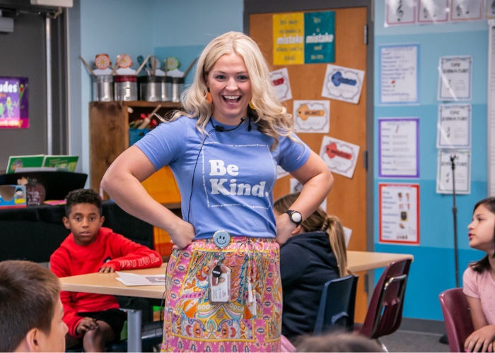 Female teacher in front of classroom.