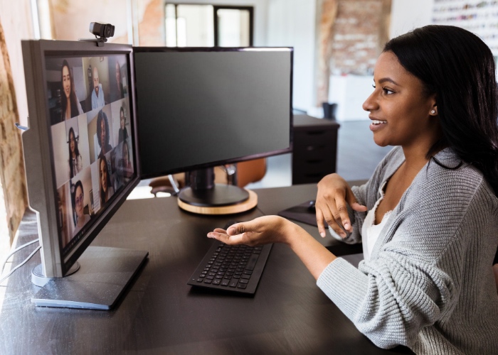 Woman at desk talking in a group video call.